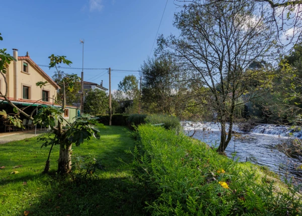 Galicia, La Coruña, Melide, view of house alonside river